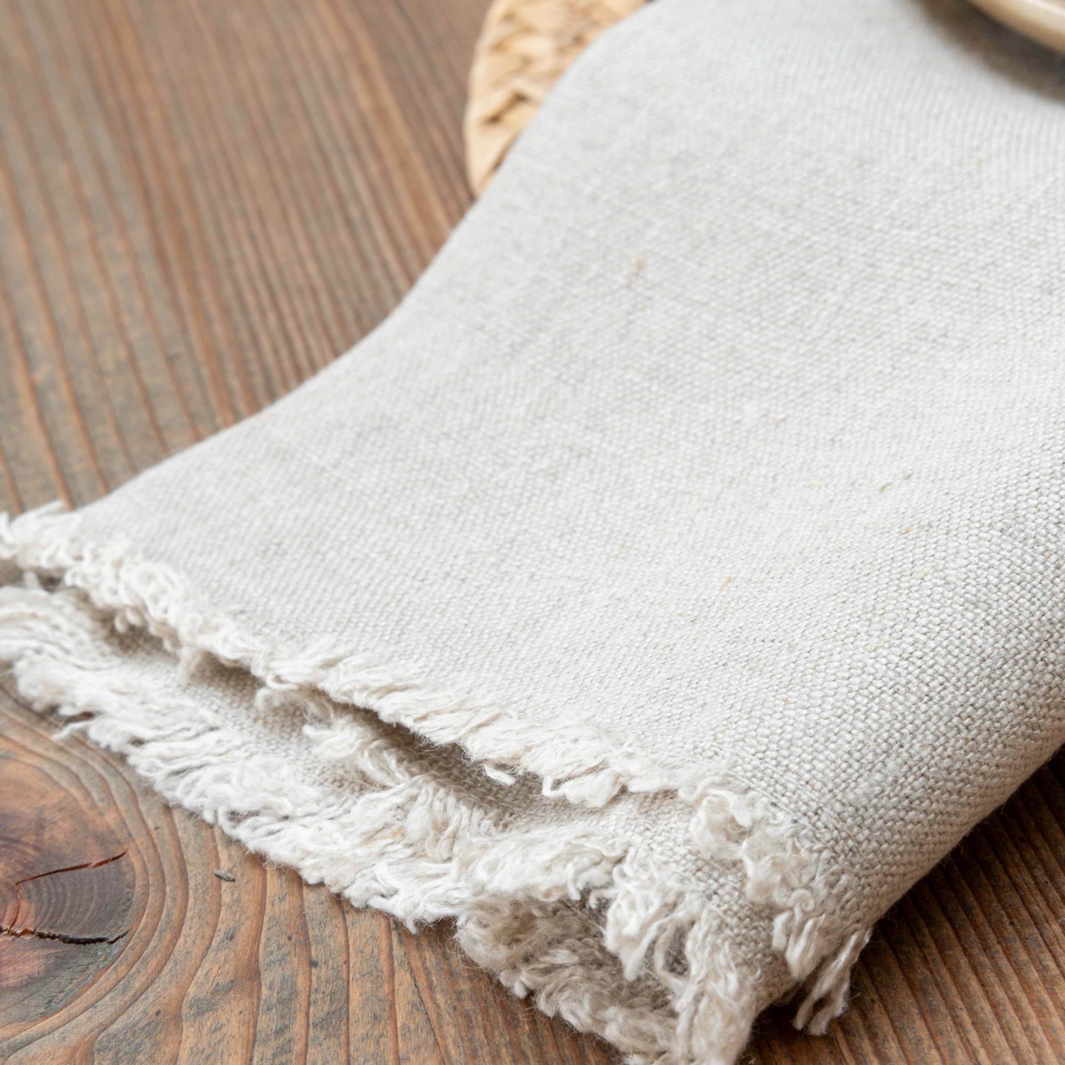 A beautiful natural linen napkin with delicate fringe detail.