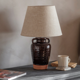 Charles Ted Adcote Rustic Brown Ceramic Table Lamp styled on console table with cup and books