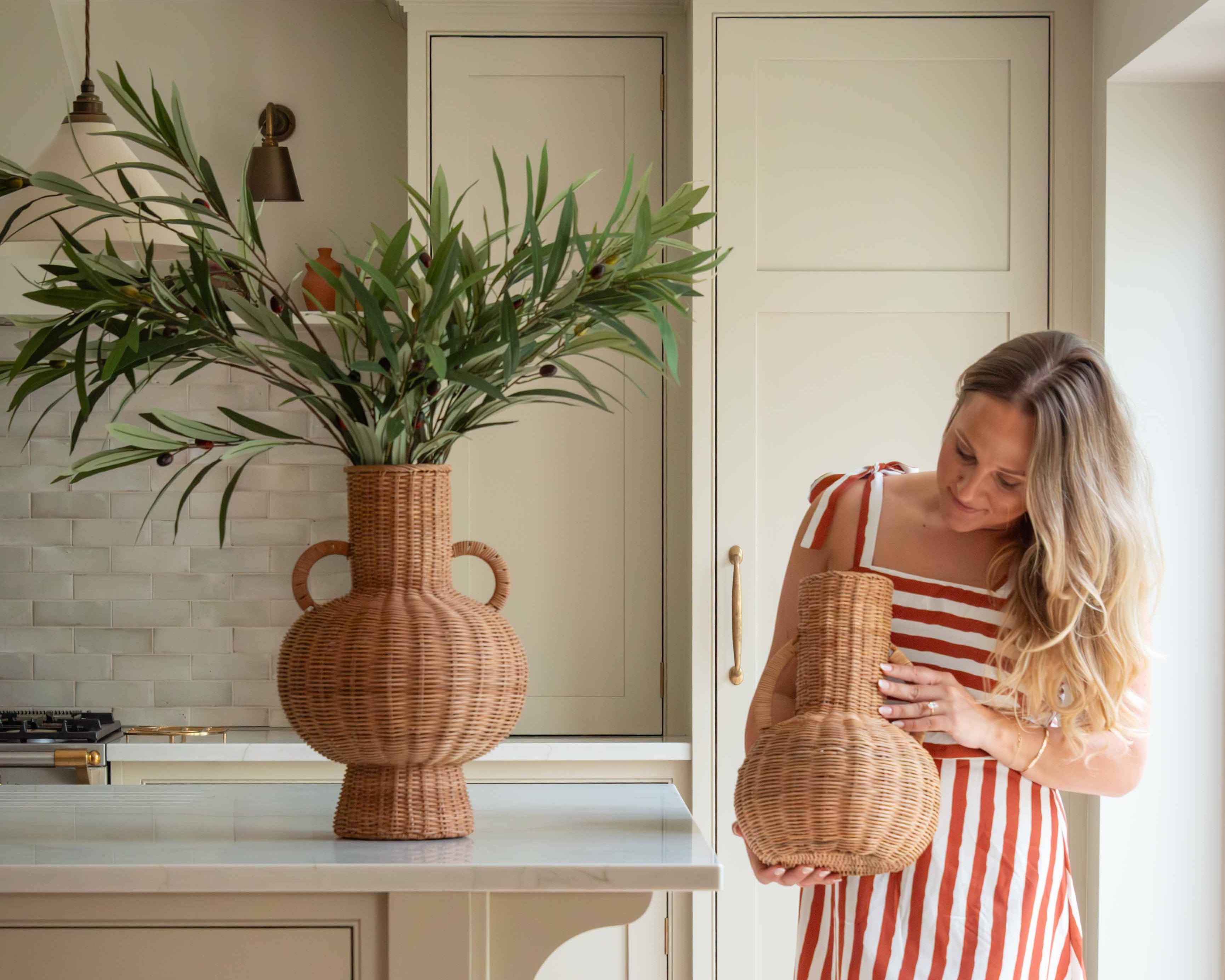 Handwoven with care and tradition, the Alderfield Jug brings the charm of rustic craftsmanship into your space. Inspired by heritage vessels once used to gather spring water or display wild blooms, this piece features a rounded base, tall neck, and two looped handles for a timeless silhouette. Made from natural rattan, its warm, earthy tones and intricate weave tell a story of simple living and enduring beauty. Whether placed on a farmhouse table or nestled in a sunlit corner, the Alderfield Jug adds textur