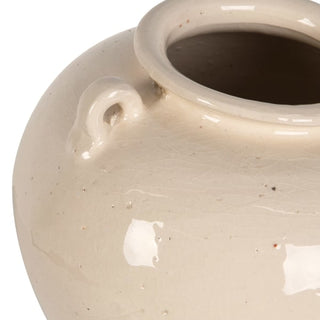 Close-up of a ceramic vase with a glossy cream-beige glaze, featuring a small loop handle and a wide flared rim on a white background.