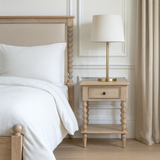 Antoine bedside table in limewashed oak with turned legs, single drawer, and open lower shelf – rustic and elegant bedroom furniture