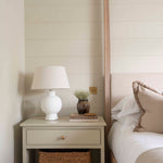 Aria White Ceramic Table Lamp styled on bedside table with books and decor