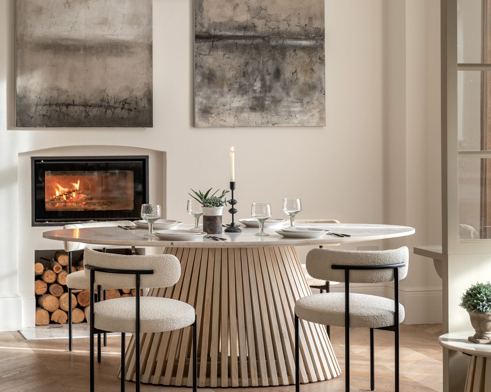 Arya oval table styled in a modern dining room with upholstered chairs and minimalist decor