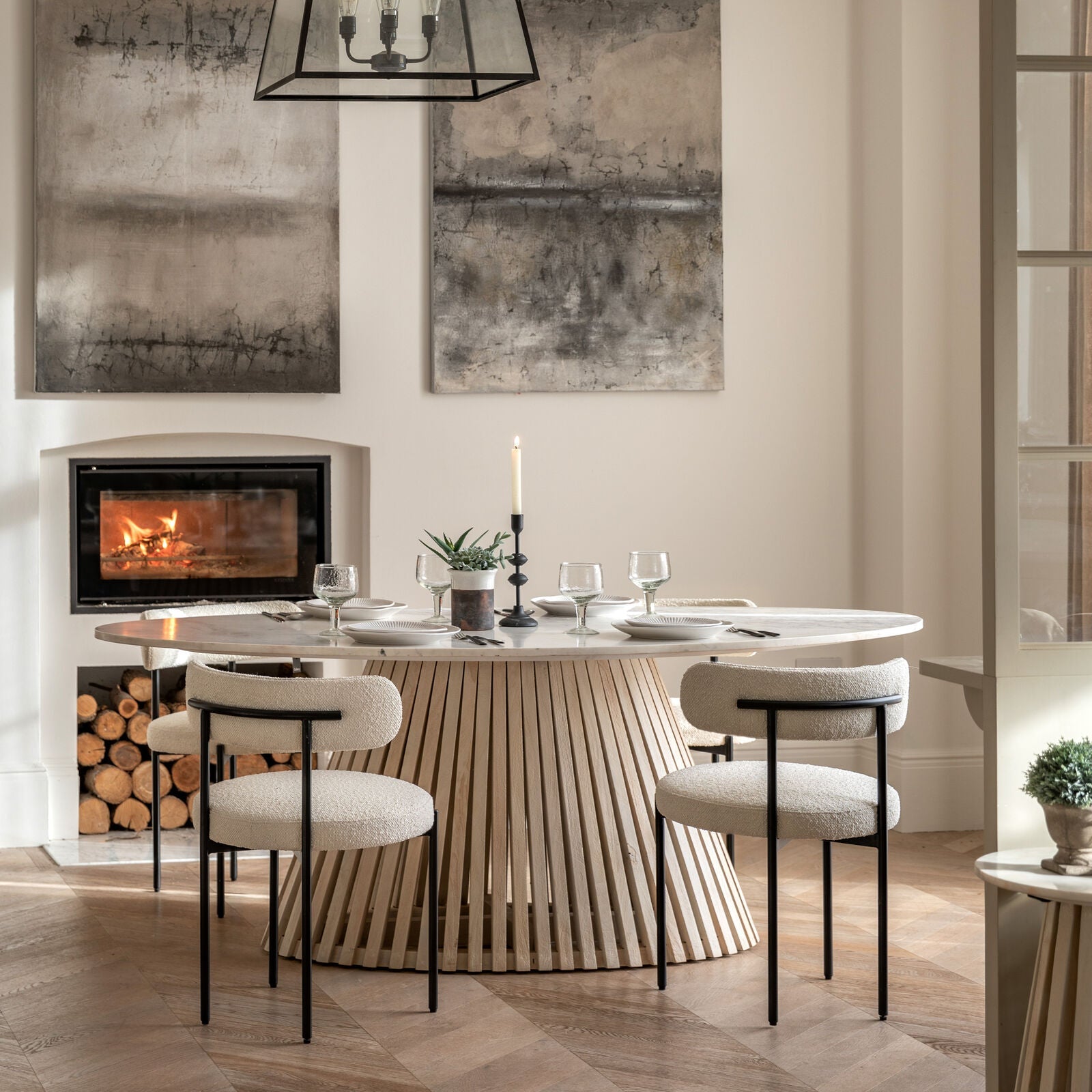 Arya oval table styled in a modern dining room with upholstered chairs and minimalist decor