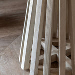 Close-up of the handcrafted pedestal base in light mango wood