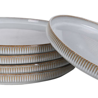 Stacked fluted dinner plates showing the reeded edge and gold-toned rim