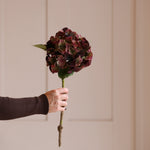A stunningly lifelike faux burgundy hydrangea with a burgundy colour and hints of green.