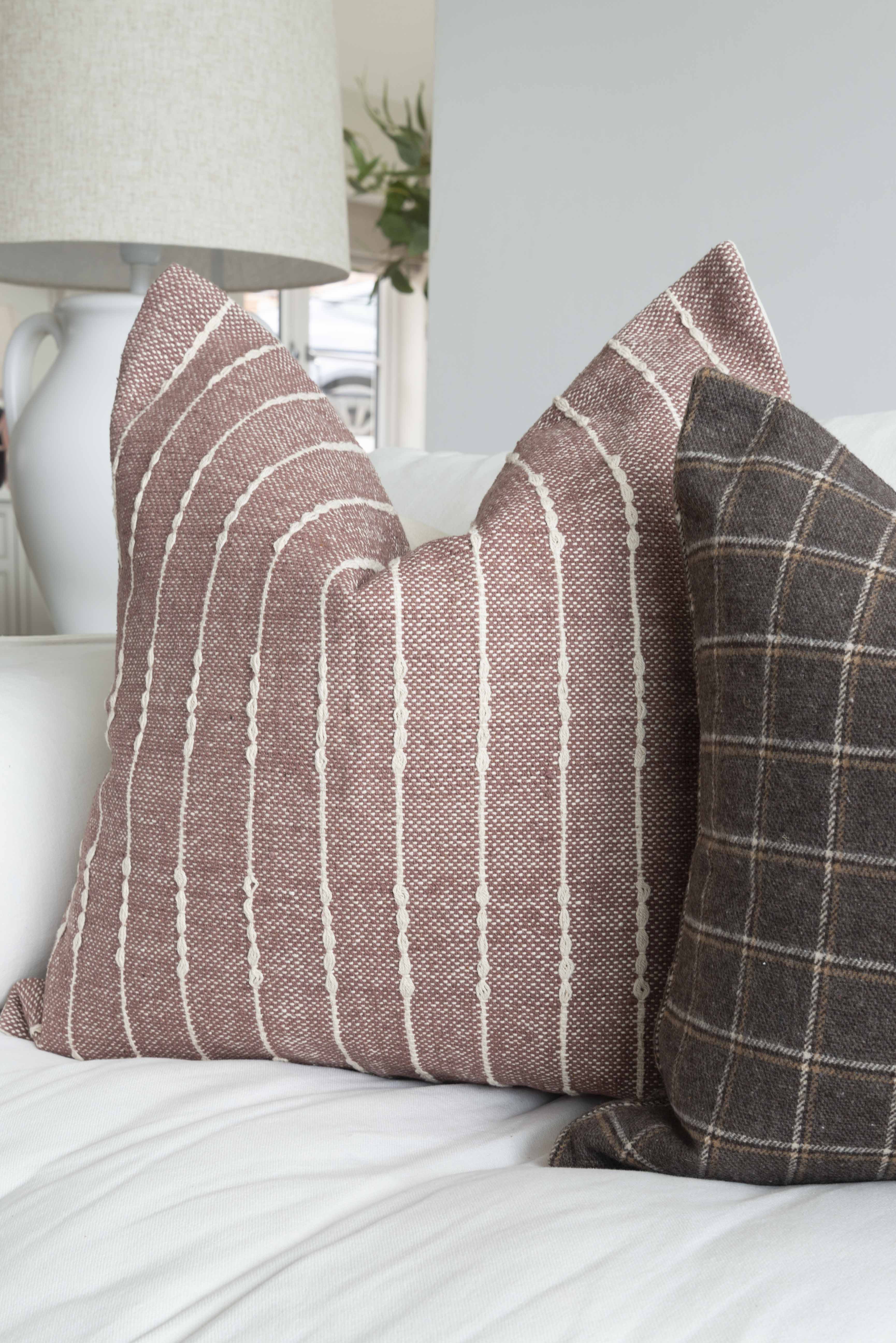 A stunning plum cotton cushion with a beautiful check Detail in cream.