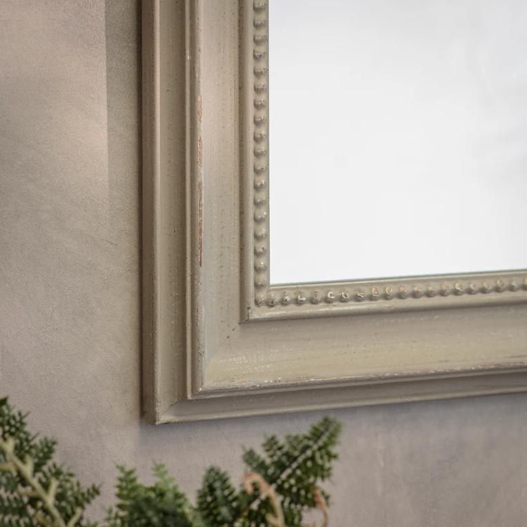 Rectangular wall mirror with rounded top and beaded frame in a distressed vintage finish