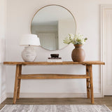 Bodie Round Mirror with soft champagne gold frame displayed above a wooden console table
