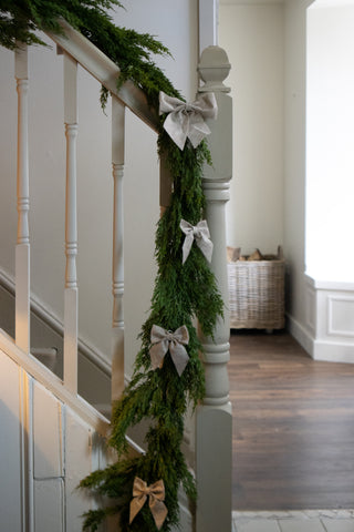 Linen felt Christmas bows tied along a staircase garland