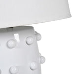  Crafted from sleek white ceramic and adorned with elegant bobble detailing, this lamp comes complete with a crisp white shade. 