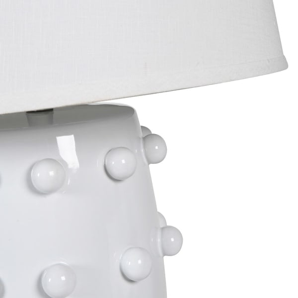  Crafted from sleek white ceramic and adorned with elegant bobble detailing, this lamp comes complete with a crisp white shade. 