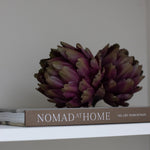 A set of three decorative faux green and purple artichokes.