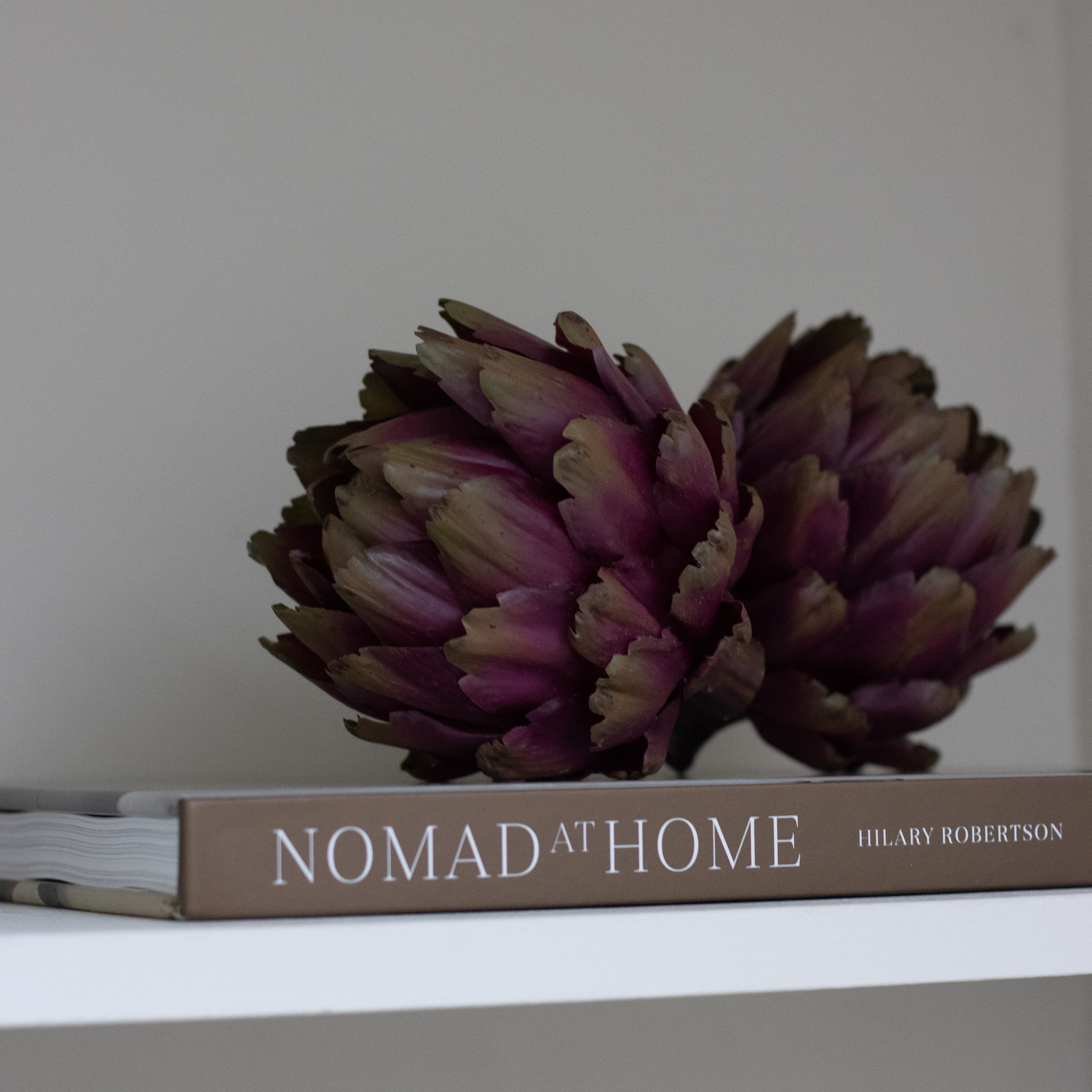 A set of three decorative faux green and purple artichokes.