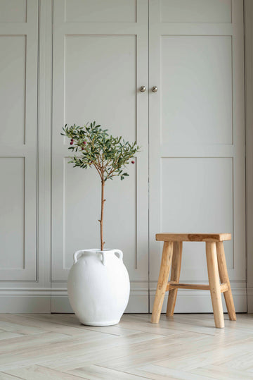 Faux olive tree in a white ceramic vase