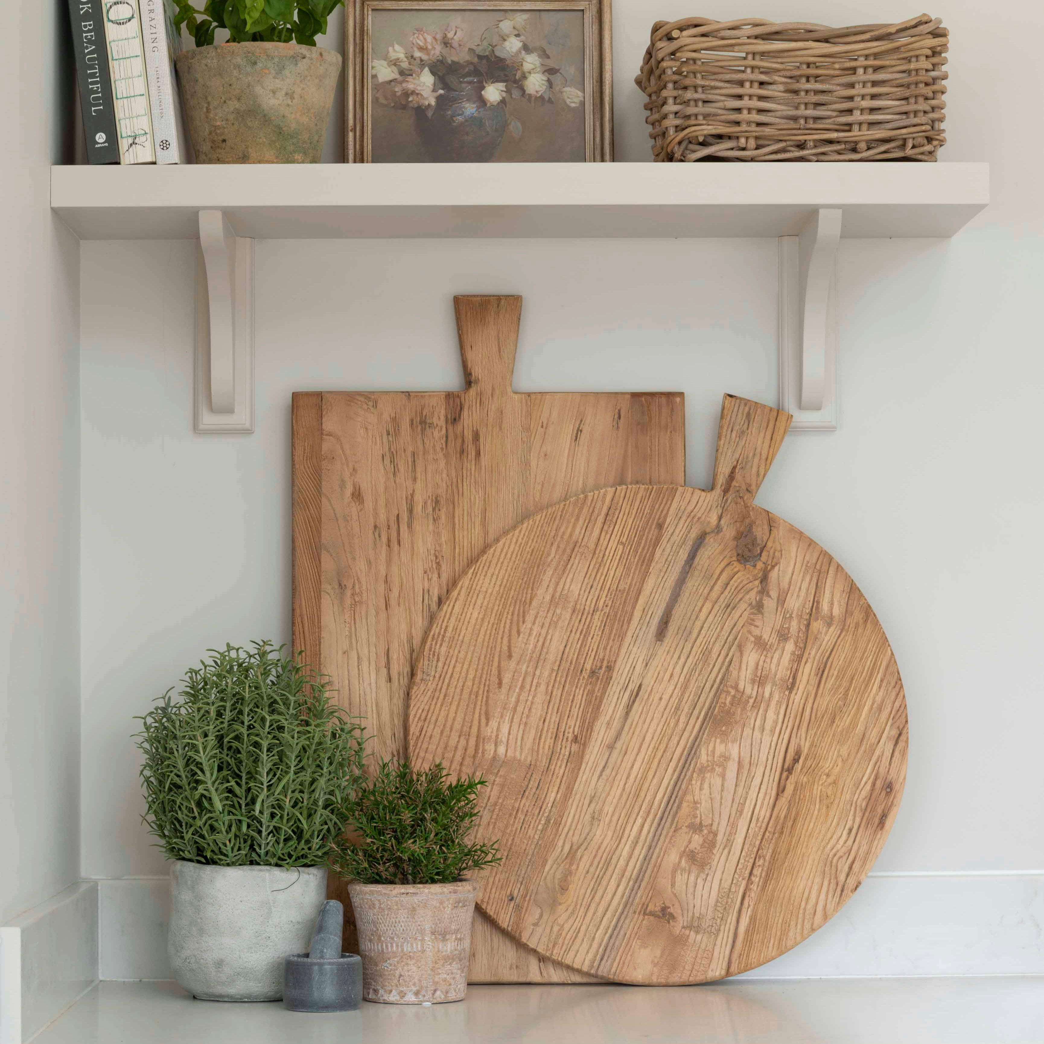 Artificial basil plant in a stone pot adding a splash of colour to a white kitchen