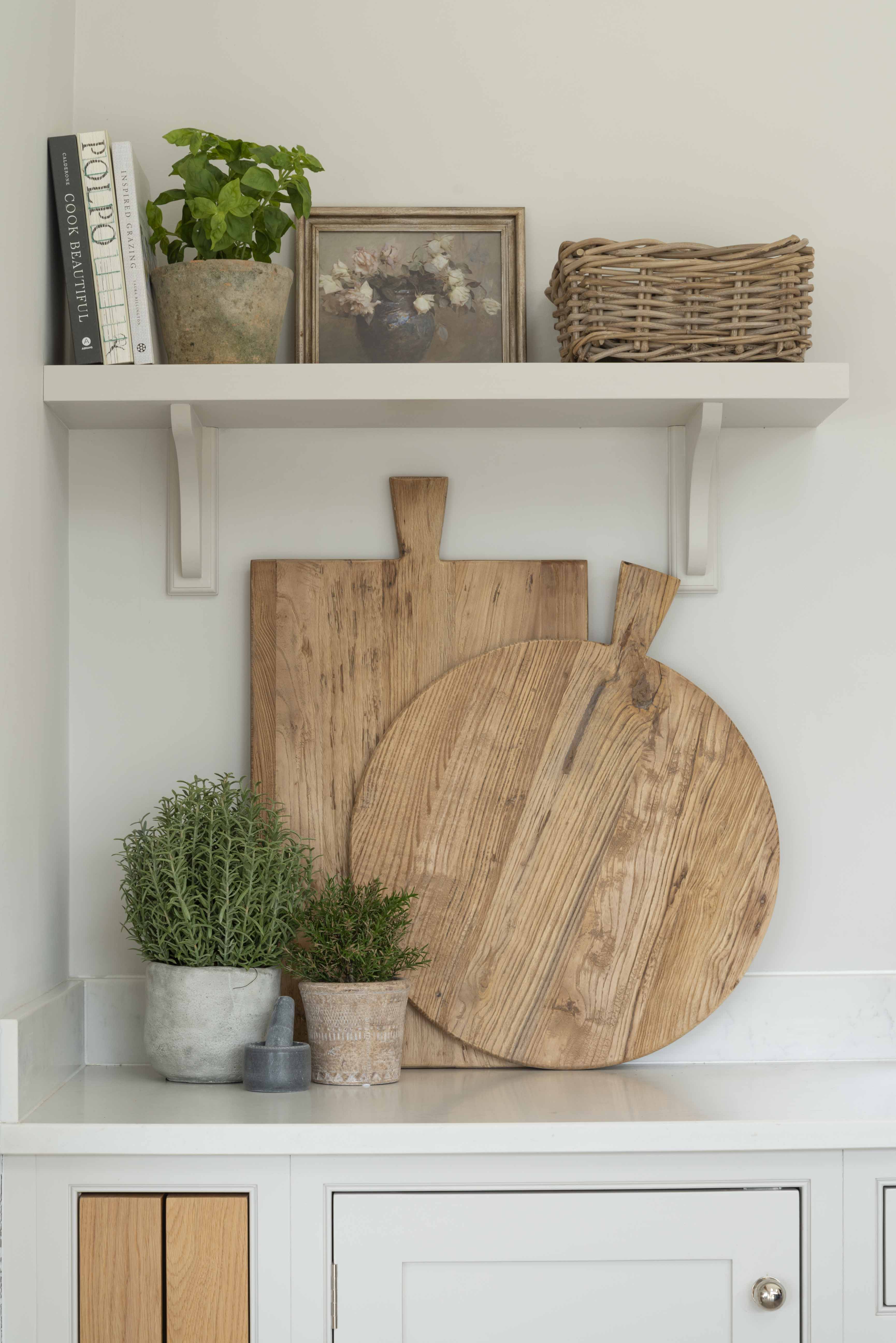 Artificial basil plant in a stone pot adding a splash of colour to a white kitchen