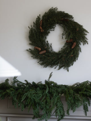 Faux cedar and pinecone wreath with natural green and brown tones