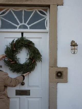 Ashdown faux cedar and pinecone Christmas wreath styled in the home