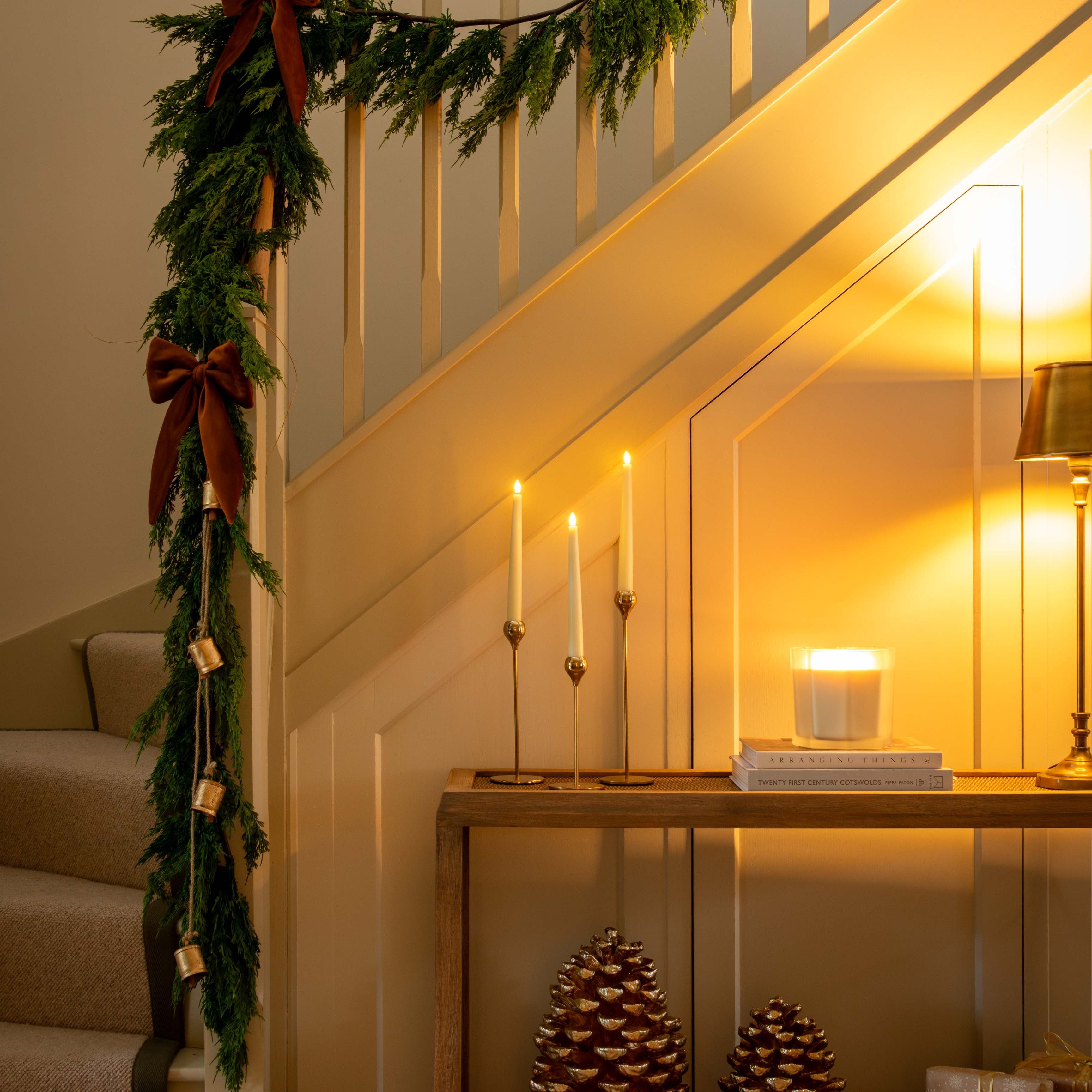 Decorative staircase with Christmas garland, candles, and decorative items.