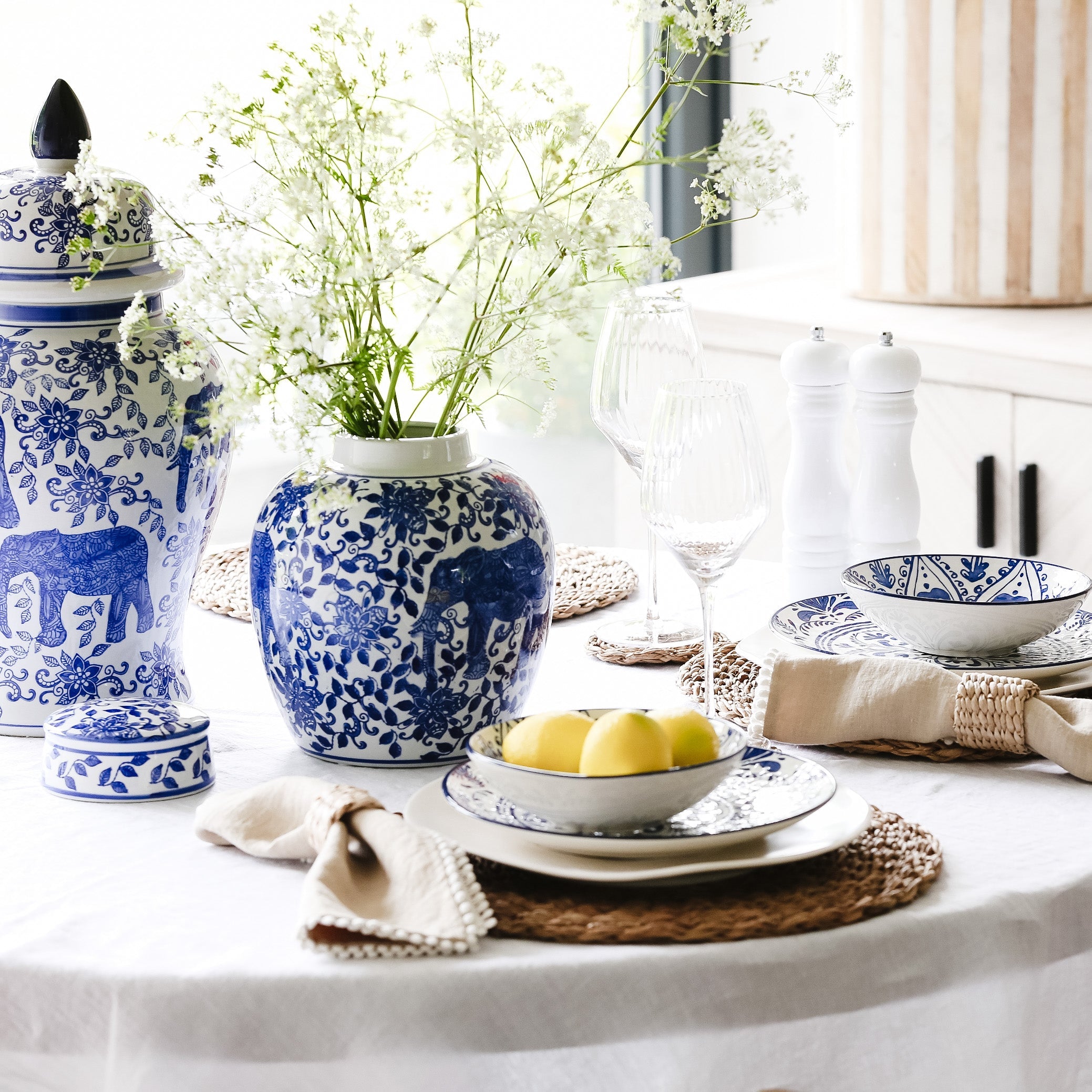Decorative table setting with blue and white patterned vases and plates.