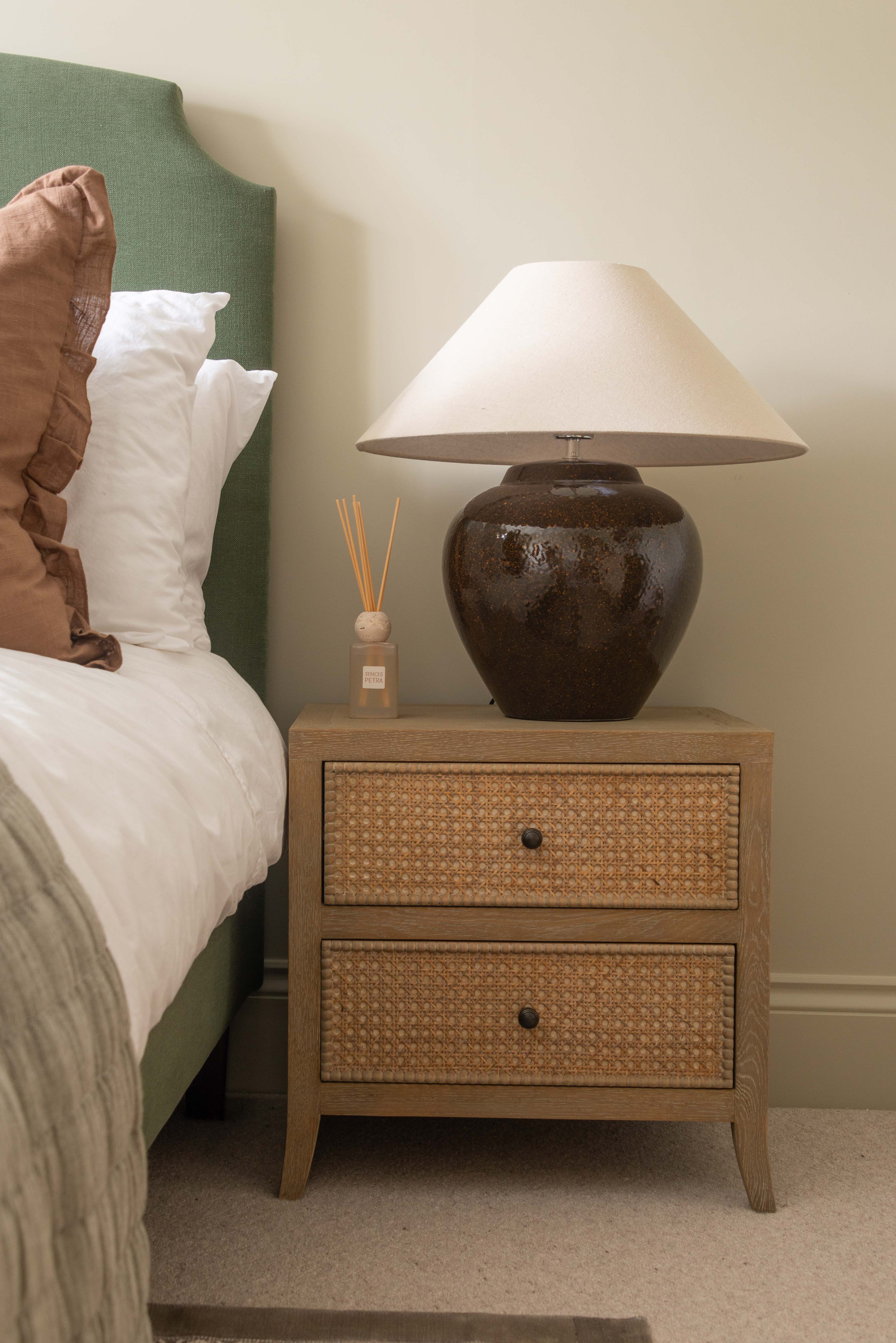 Charles Ted Evelyn Rustic Grey Oak Bedside Table with 2 Rattan Latticed Drawers beside bed with lamp