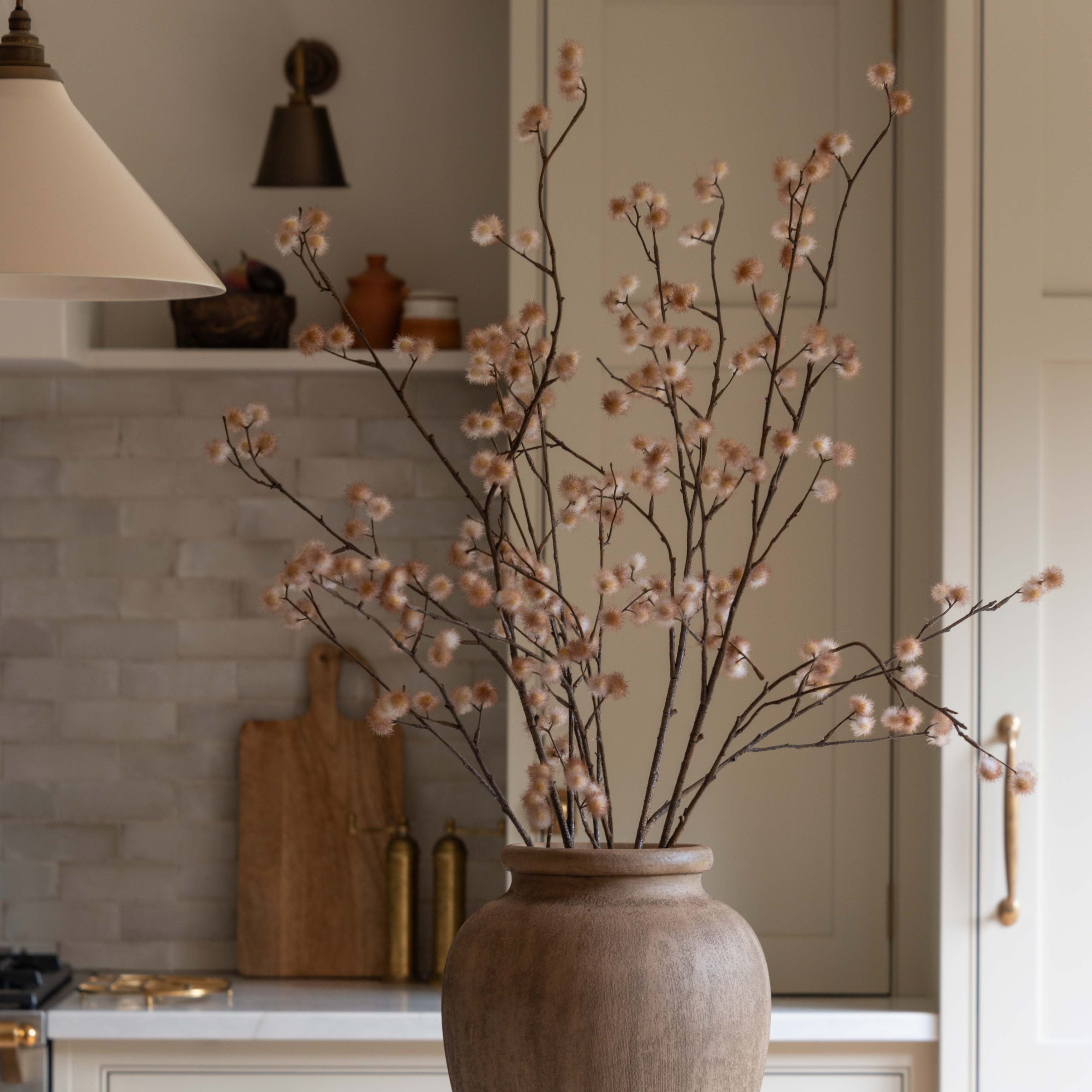 Charles Ted Faux Dusky Pink Blossom Spray Stem in brown vase on marble countertop