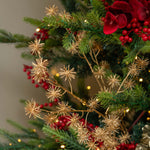 Decorative Christmas tree with red berries and gold branches against a blurred background