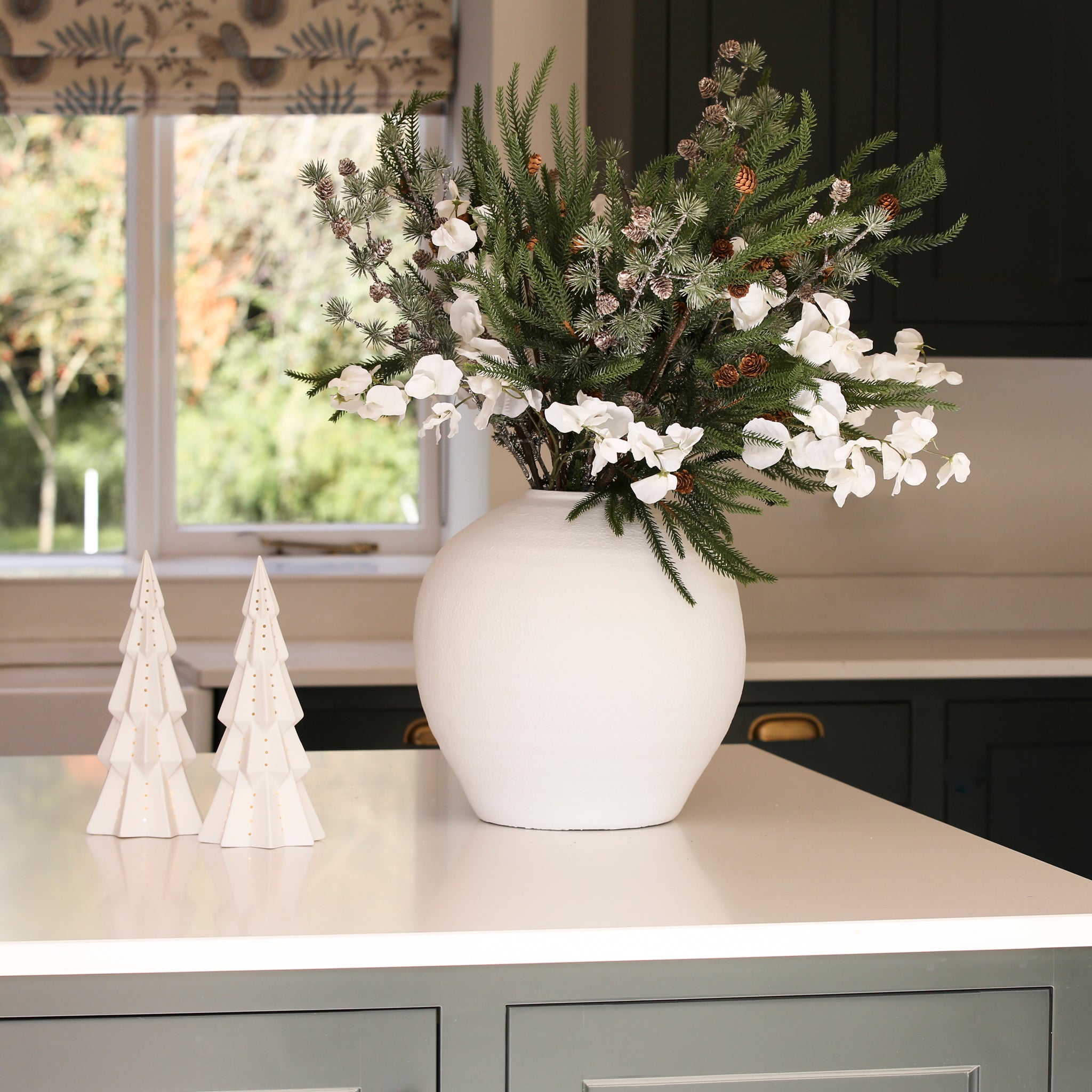 Charles Ted Lit Decorative Christmas Tree styled on a counter next to a festive floral arrangement