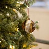 Charles Ted Marble Glass Baubles in bronze and cream tones hanging on a Christmas tree