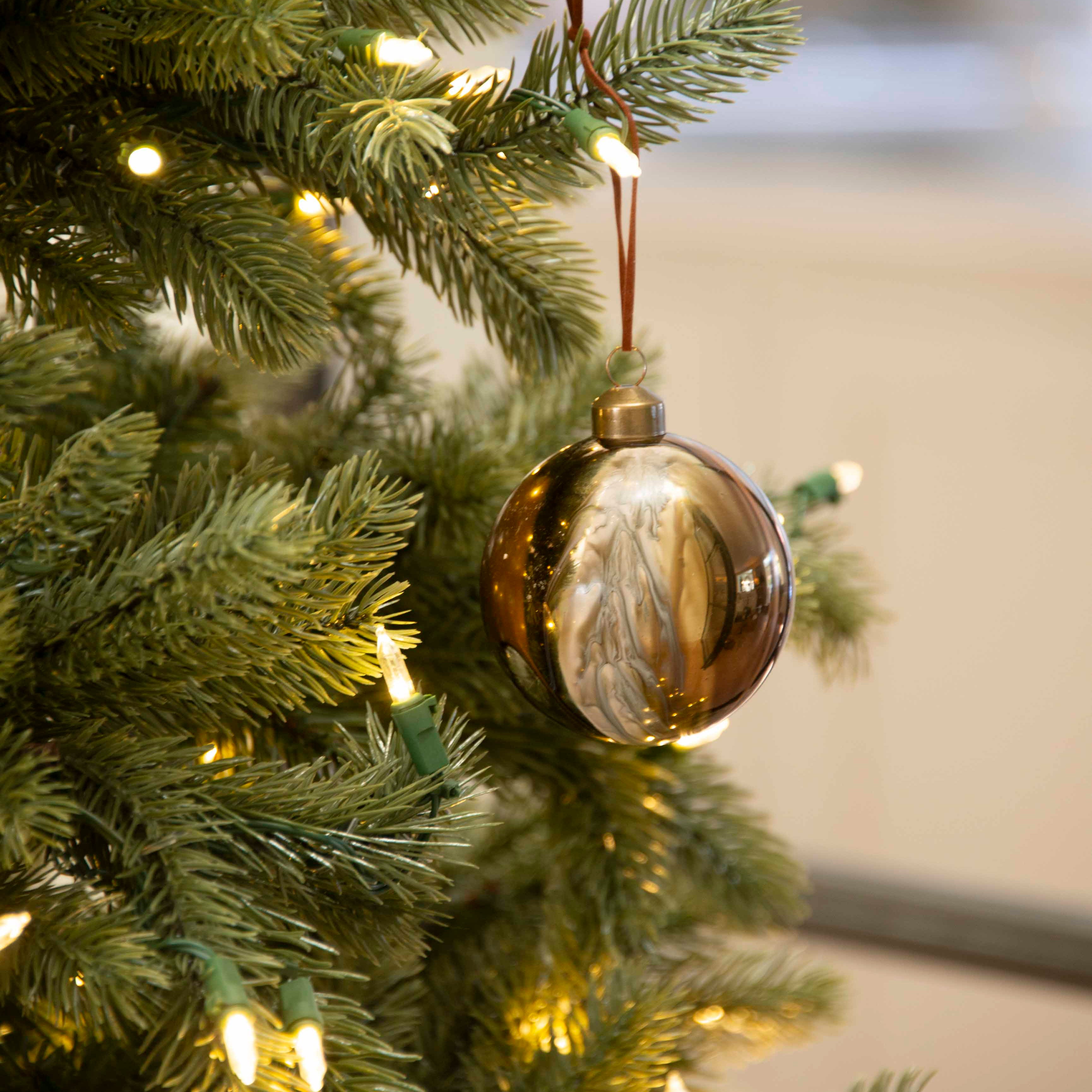 Charles Ted Marble Glass Baubles in bronze and cream tones hanging on a Christmas tree
