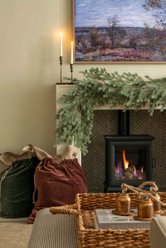 Charles Ted Noble Pine Garland with realistic pine branches and cones styled across a fireplace mantel