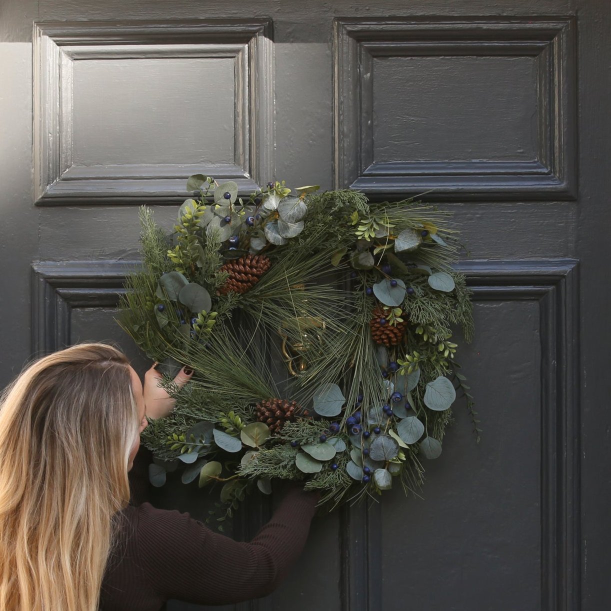 Charles Ted Pine Cone Berry and Eucalyptus Wreath hanging on door