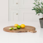 Charles Ted Round Breadboard made from recycled elm wood styled in a modern kitchen with fresh fruit and rustic decor