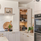 Modern kitchen with white cabinets, stainless steel appliances, and a countertop with various items.