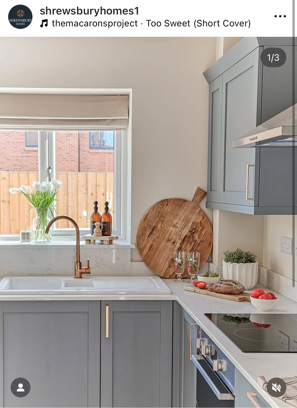 Modern kitchen with gray cabinets, white countertop, and wooden cutting board.