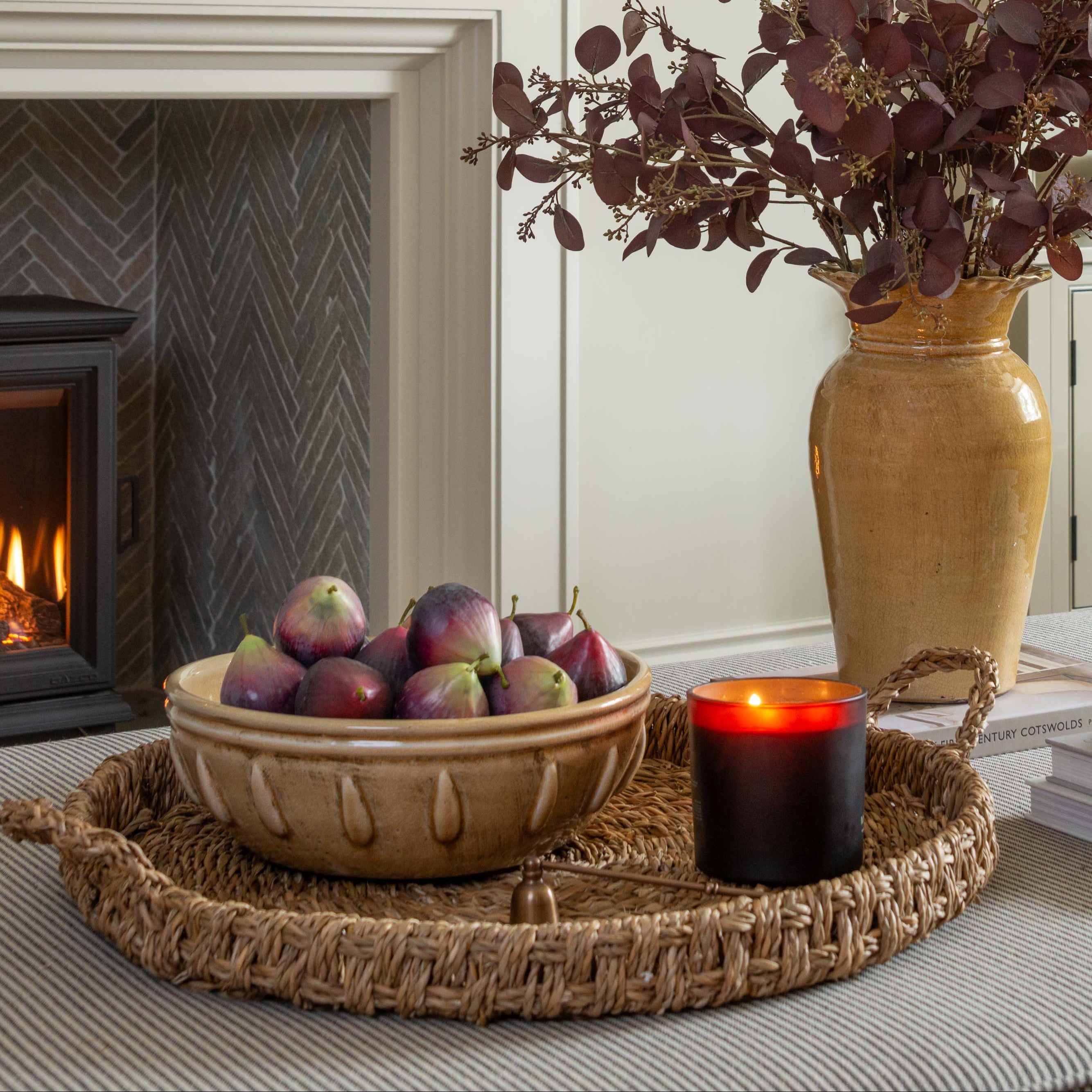 Living room with fireplace, decorative items, and a vase of flowers.