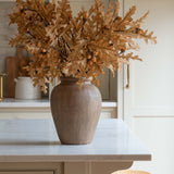 Decorative vase with dried foliage on a kitchen counter