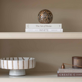 Charles Ted Striped Footed Terracotta Bowl with vertical neutral stripes displayed on a shelf