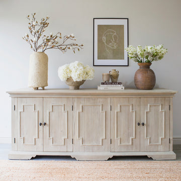 Crafted from recycled pine, this cabinet showcases four doors adorned with bronze metal handles and a rustic finish.