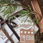 Gift with a gingerbread house tag and pine branch