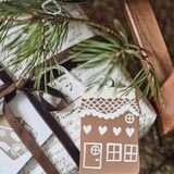 Gift with a gingerbread house tag and pine branch