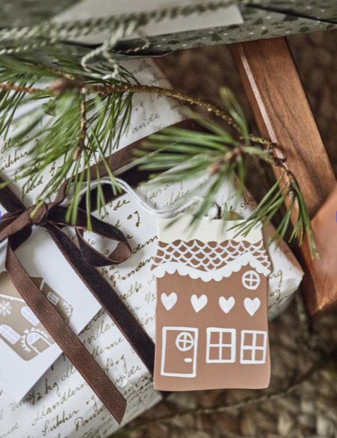 Gift with a gingerbread house tag and pine branch