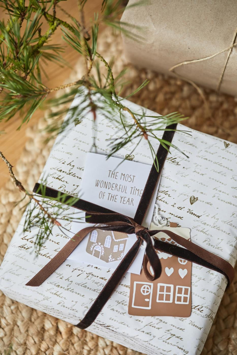 Christmas present decorated with chestnut velvet ribbon and festive tags