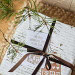 Christmas present decorated with chestnut velvet ribbon and festive tags