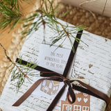 Christmas present decorated with chestnut velvet ribbon and festive tags