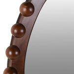Round wooden mirror with chestnut-style orb frame close up 