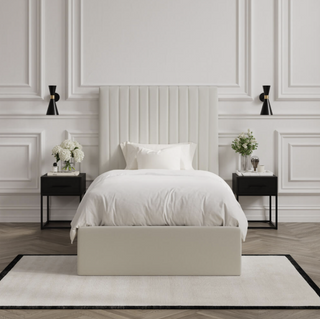 Chiltern cream ottoman storage bed styled in a panelled bedroom with fluted headboard and black bedside tables