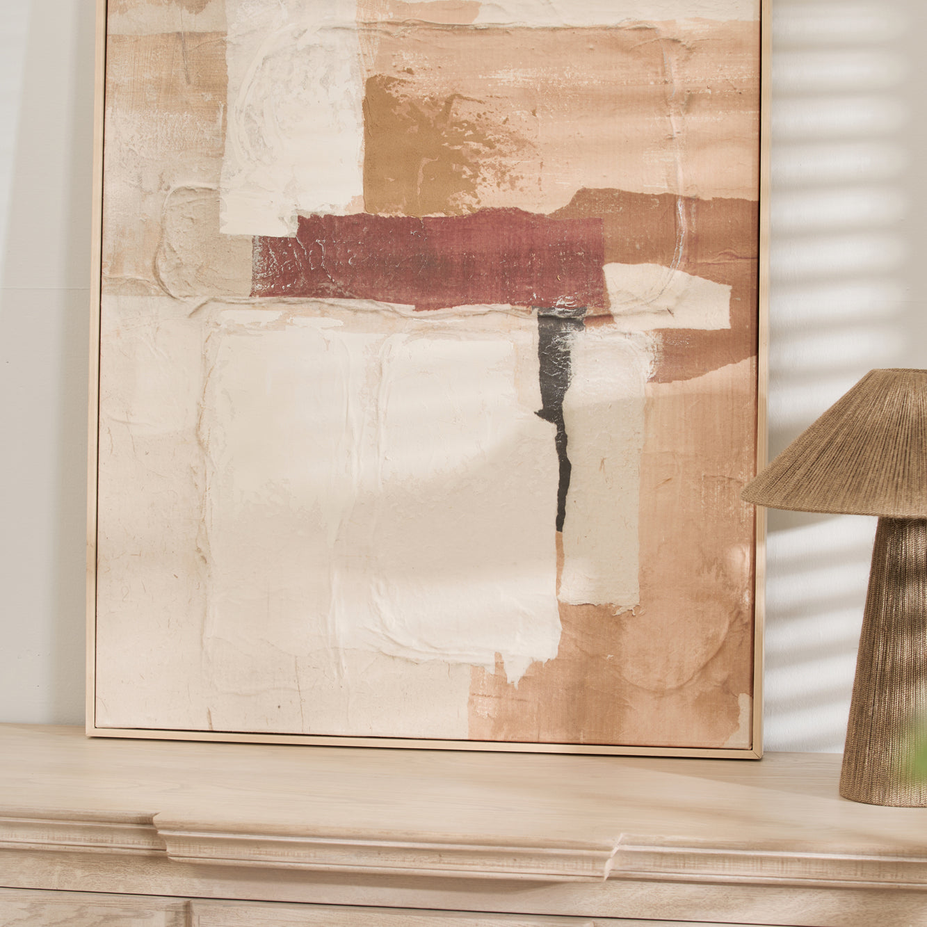 Abstract wall art styled on a light wood console with neutral home decor